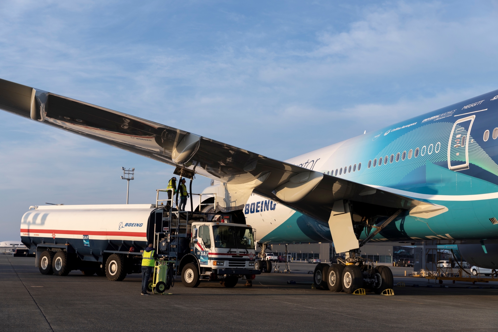 A photograph of a Boeing aircraft being refueled with Sustainable Aviation Fuel from a truck on the tarmac. 
